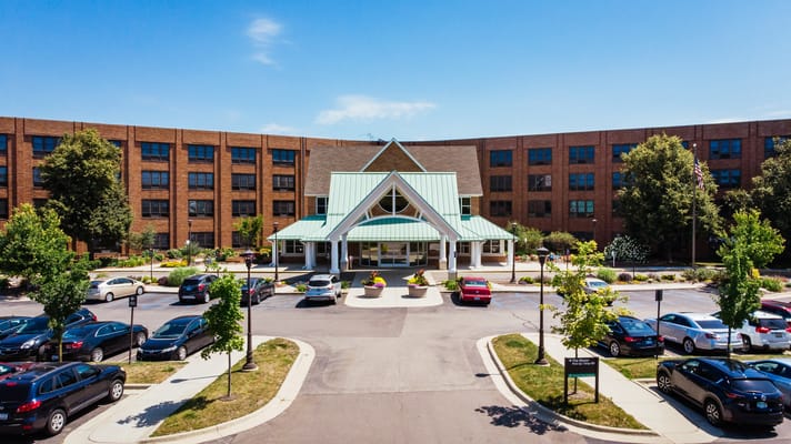 Entrance of Glacier Hills senior living facility with green roof and surrounding parking area.