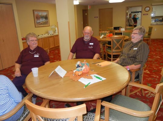 Residents and staff engaged in conversation around a table