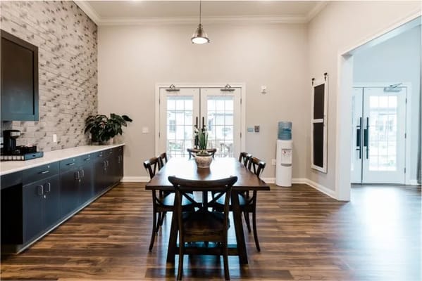 Bright dining area featuring a long wooden table and modern decor