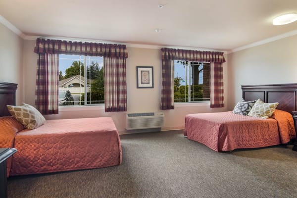 Bright double room with two beds and large windows