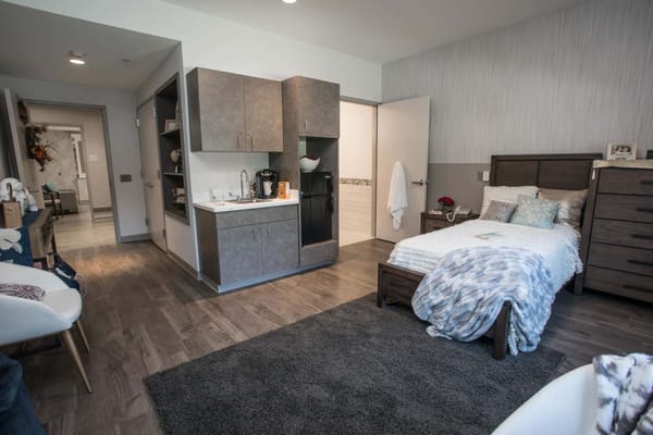 A private resident room showing a bed and kitchenette