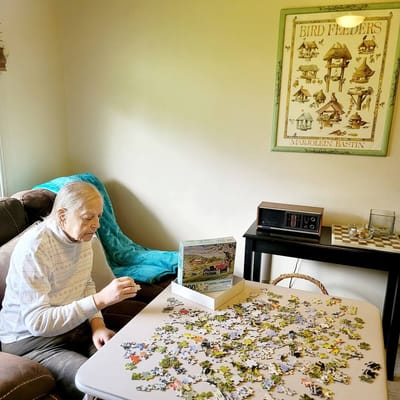 An elderly resident working on a puzzle