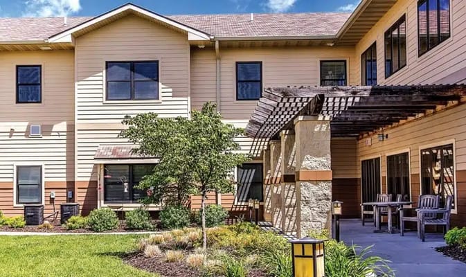 Exterior view of a senior living facility with outdoor seating