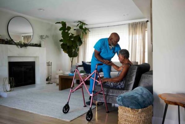 A caregiver interacts with a resident in a cozy living area.
