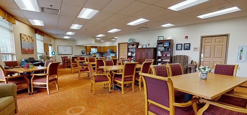 Bright common area with tables and seating for residents