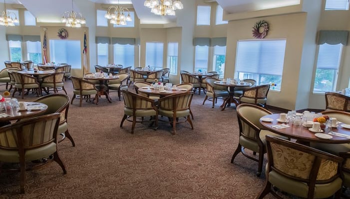 View of the dining room with round tables and chairs.