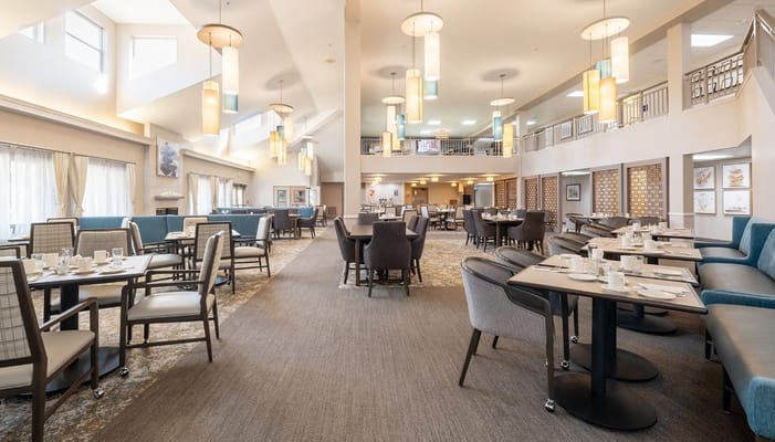 Bright dining room with tables and chairs set for meals