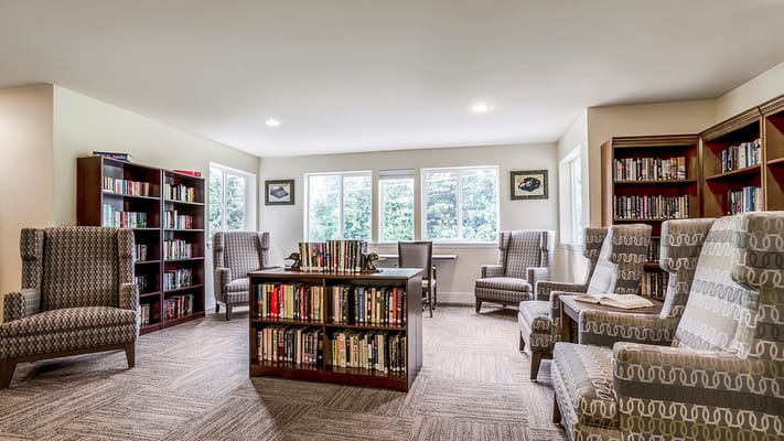 A well-lit library with bookshelves and comfortable seating