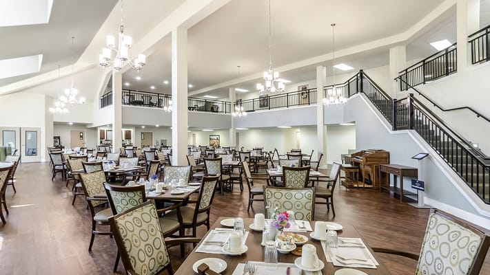 Spacious dining area in Holiday Greenwood Terrace with tables set for a meal.
