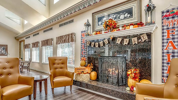 Living room decorated for fall with chairs and a fireplace