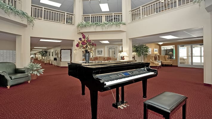 Interior view of a facility lobby with piano and seating area