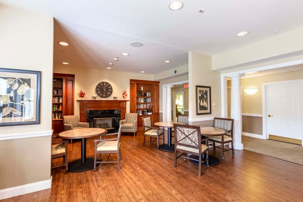 Cozy lounge area with tables and chairs in a senior living facility