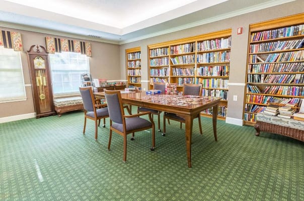 Cozy library with bookshelves and a game table