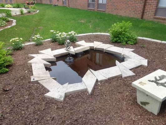 A tranquil outdoor garden pond with a small fountain