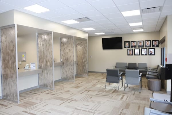 Interior view of a waiting area with seating and wall photos