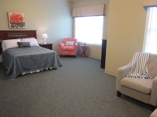 A cozy resident room with a bed and seating area