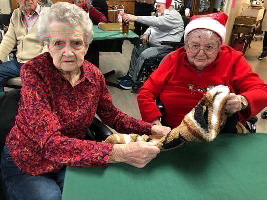 Two seniors sharing a blanket during a gathering at Kingsley Specialty Care.