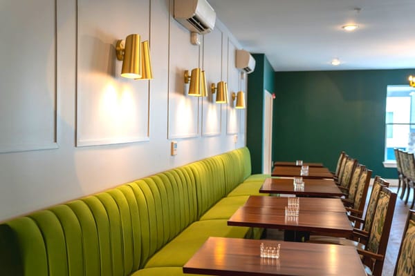 Interior of a dining room with green seating and tables