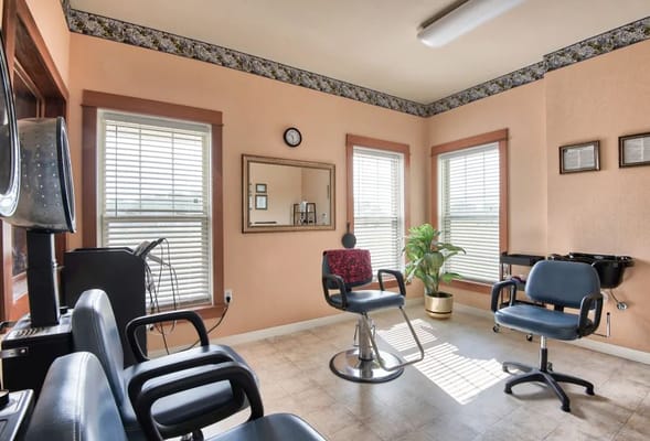 Interior of a hair salon with styling chairs and natural light.