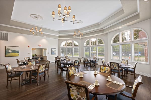Bright and spacious dining area with wooden tables and floral chairs