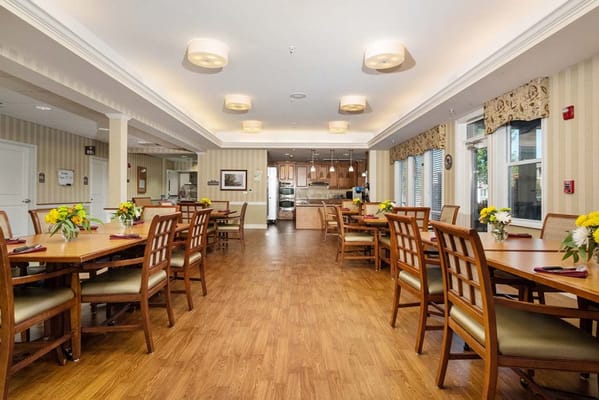 Bright dining room with wooden tables and floral centerpieces