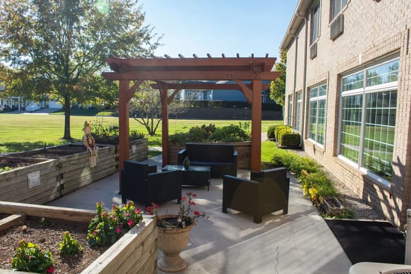 Outdoor seating area with a pergola and garden plants