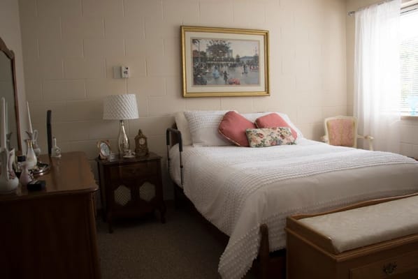 Cozy bedroom with bed, dresser, and artwork