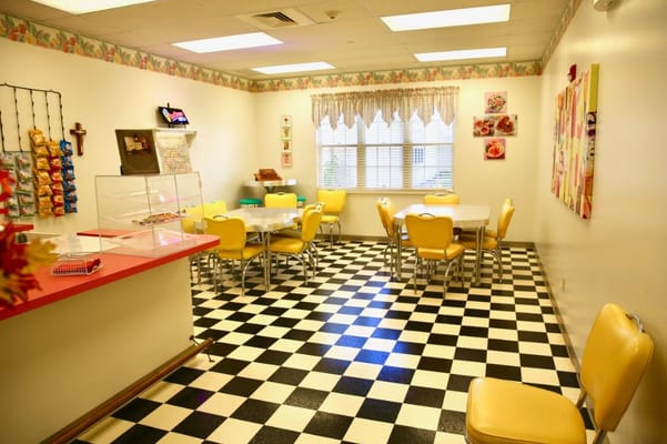 Bright dining room with checkered floor and yellow chairs