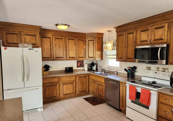 Bright kitchen area with wooden cabinets and appliances