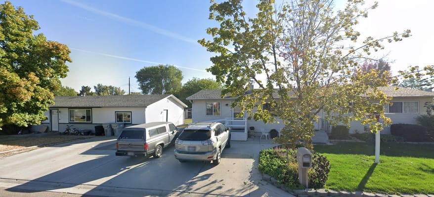 Exterior view of a residential care home with vehicles