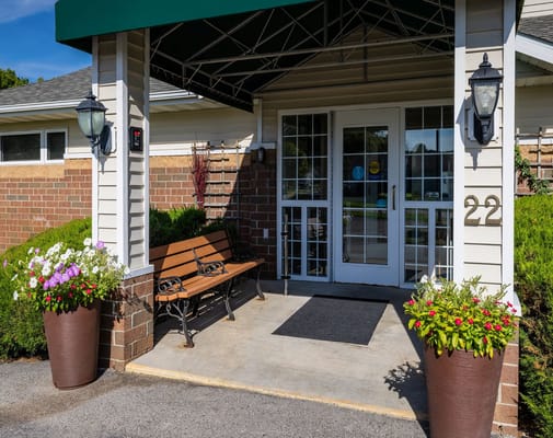 Front entrance with seating and flower pots at Meadow Lakes Senior Living