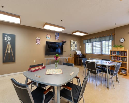 A cozy game room with tables, chairs, and colorful decor.