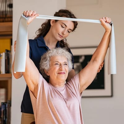 Staff assisting a resident with physical therapy exercises