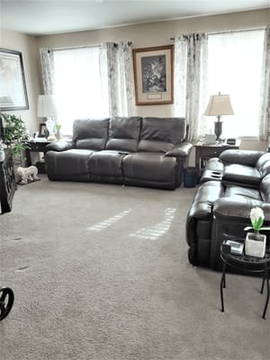Spacious living room with leather sofas and natural light
