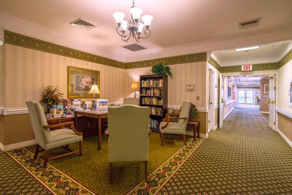 Cozy common area with seating and bookshelf in a senior living facility