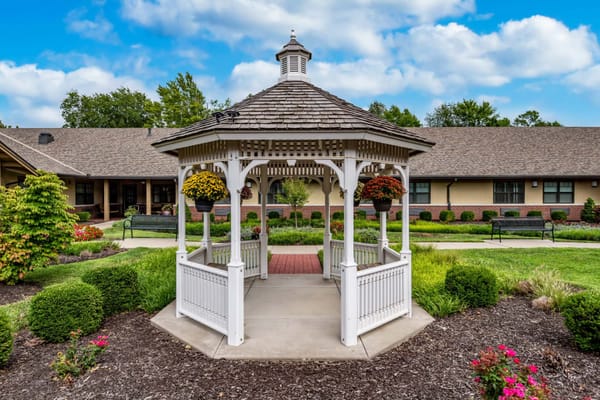 White gazebo surrounded by a landscaped garden