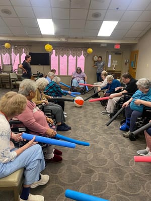 Seniors participating in an exercise activity with foam rollers