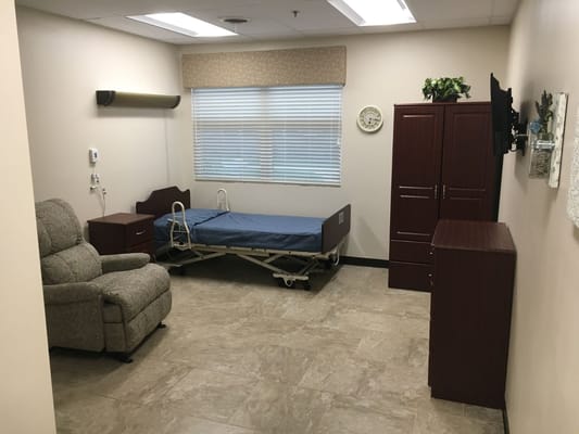 Private resident room with bed and recliner chair