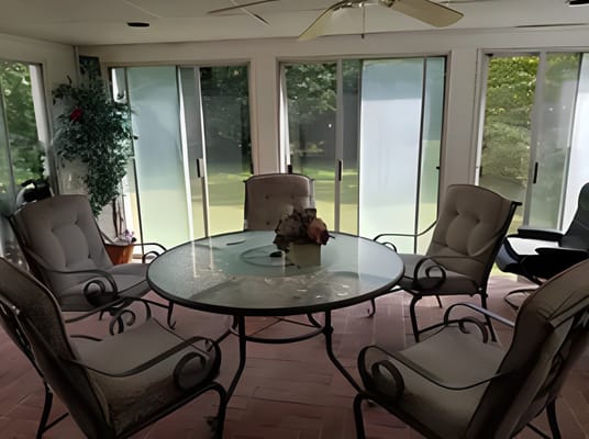 Bright sunroom with comfortable seating and a table