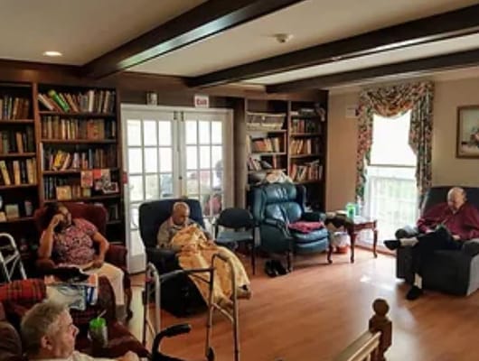 Residents relaxing in a cozy common area with bookshelves