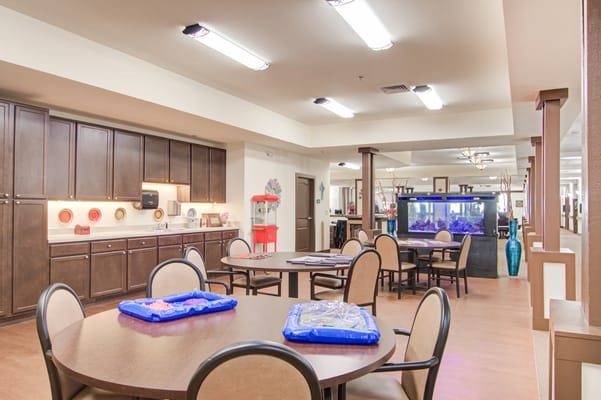 Bright common area with tables and an aquarium