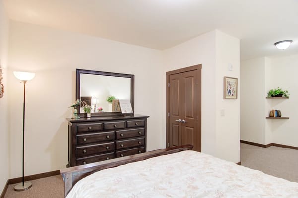 Well-furnished private resident room with a bed and dresser