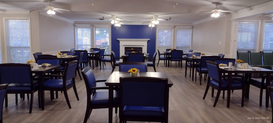 Dining room with tables set for meals and decor featuring sunflowers.