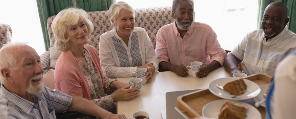 Residents enjoying coffee and cake together at a table