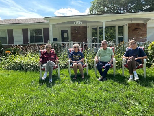 Residents enjoying time outdoors in front of the facility