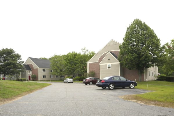 View of the exterior of Oxford Meadow Apartments with parking area.