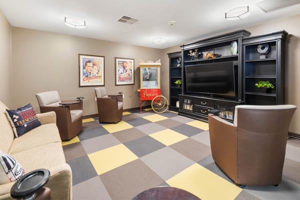 Cozy lounge with a television, popcorn machine, and comfortable seating