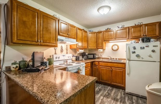 A kitchen area with wooden cabinets and appliances