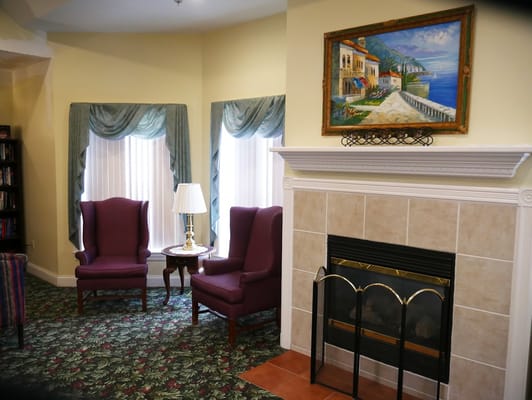Comfortable purple armchairs next to a fireplace in a warm living room setting.