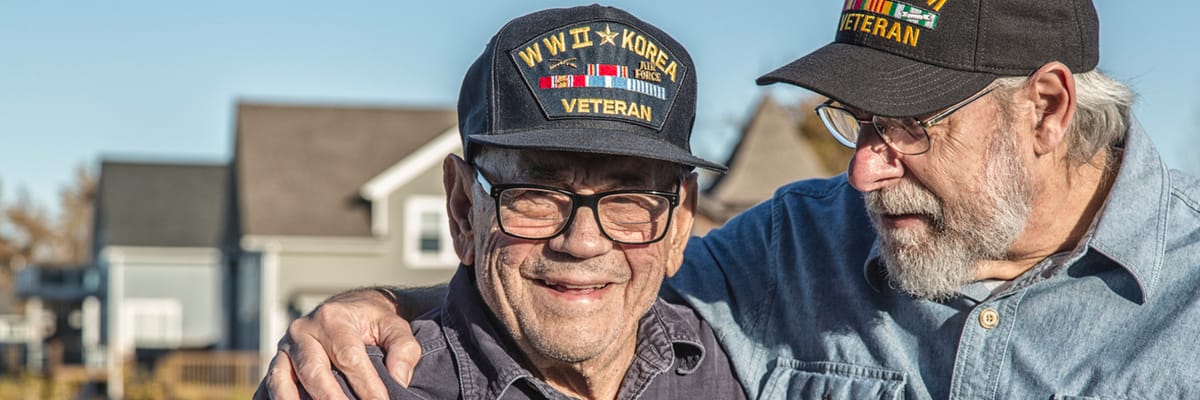 Two veterans smiling together outdoors